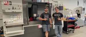 CGCC instructors stand in front of CNC machine.