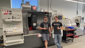 CGCC instructors stand in front of CNC machine.